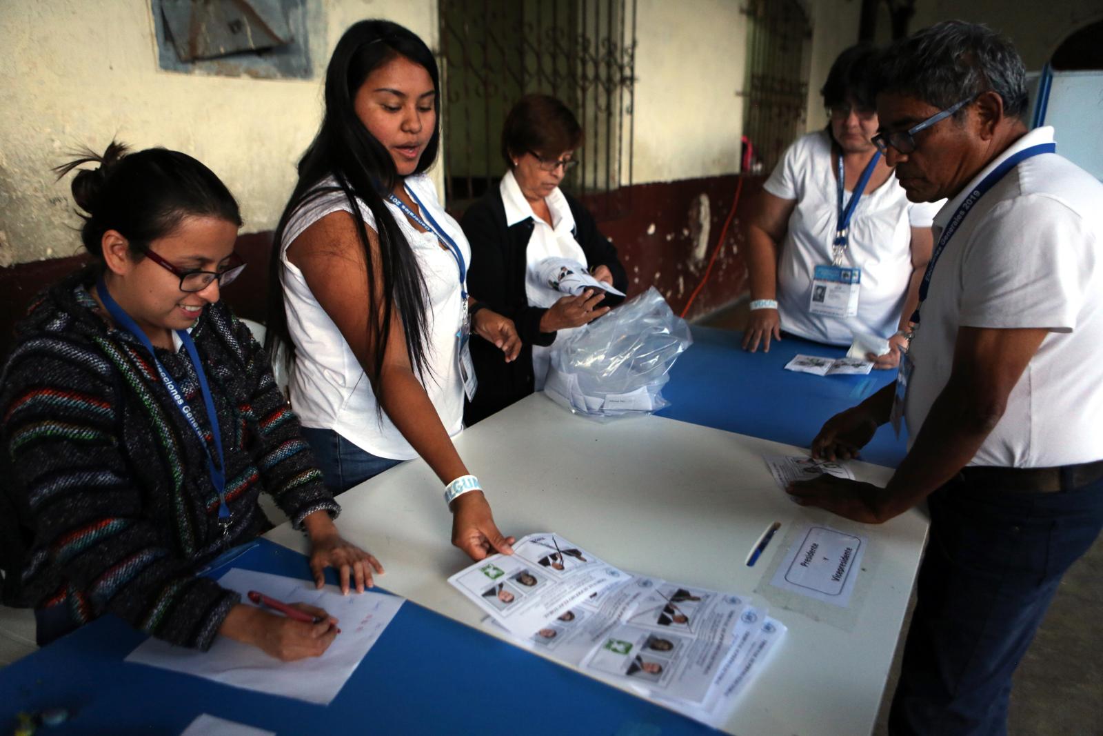 Election officials start counting marked ballots after polling stations closed during general elections in Guatemala City, Sunday, Aug. 11, 2019.