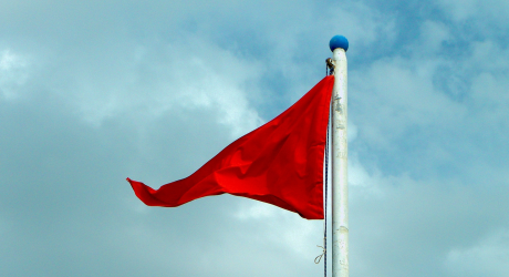 Red Flag against cloudy background