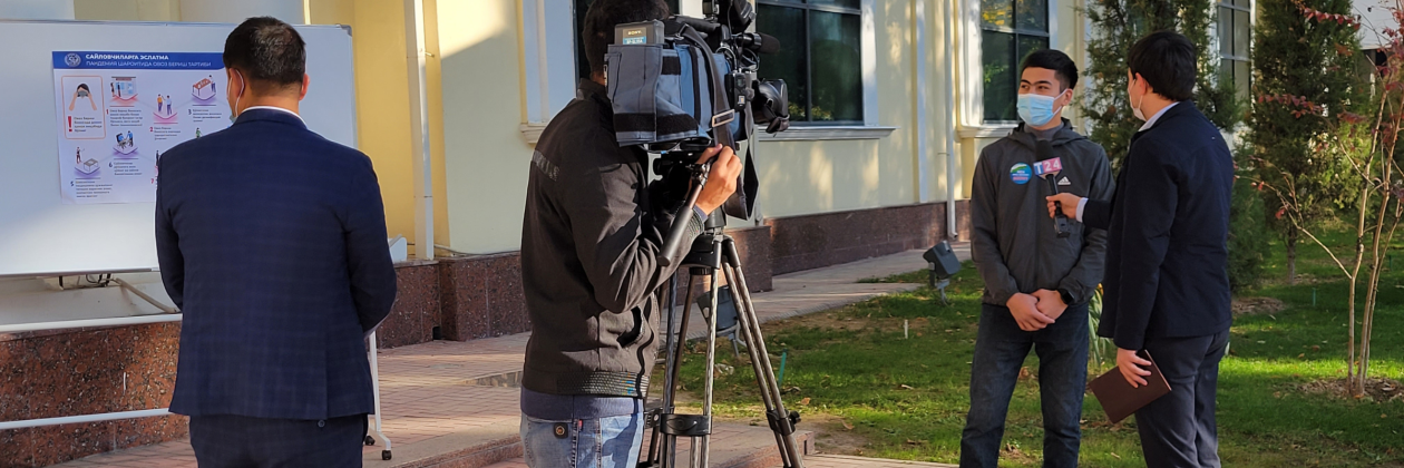 person operating camera  with reporter in Uzbekistan.