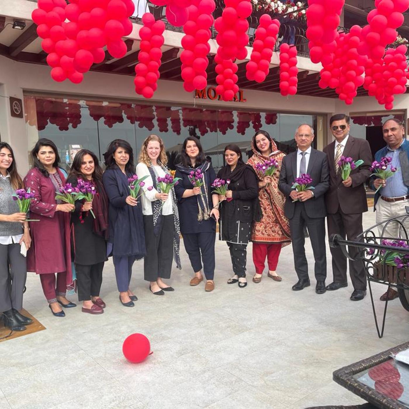 IFES Pakistan stands together under flowering tree for IWD 2023