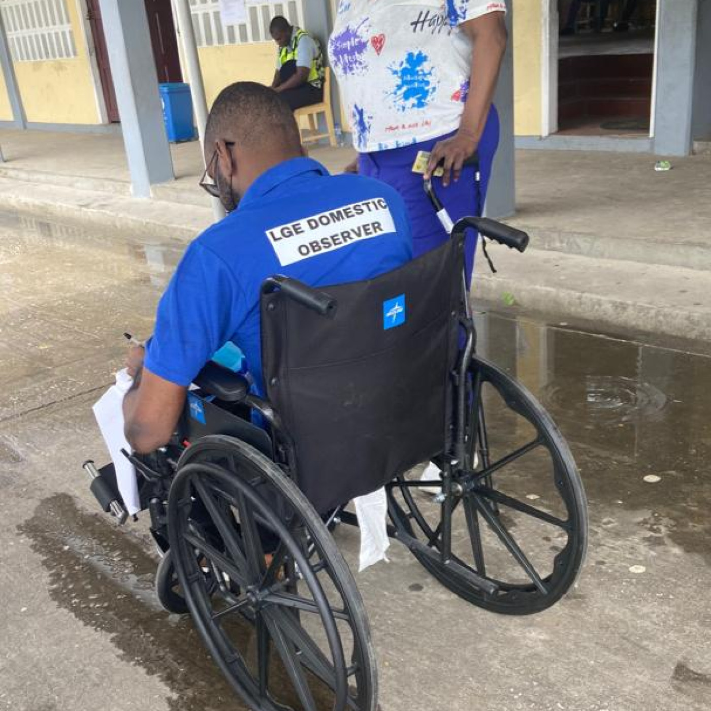 Election observer using a wheelchair chatting with a colleague 