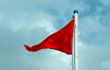 Red Flag against cloudy background