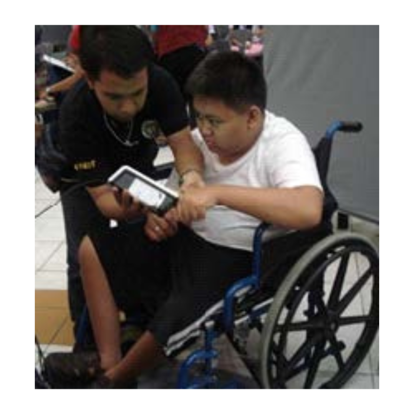 A young man who uses a wheelchair uses a biometric voter registration machine in the Philippines