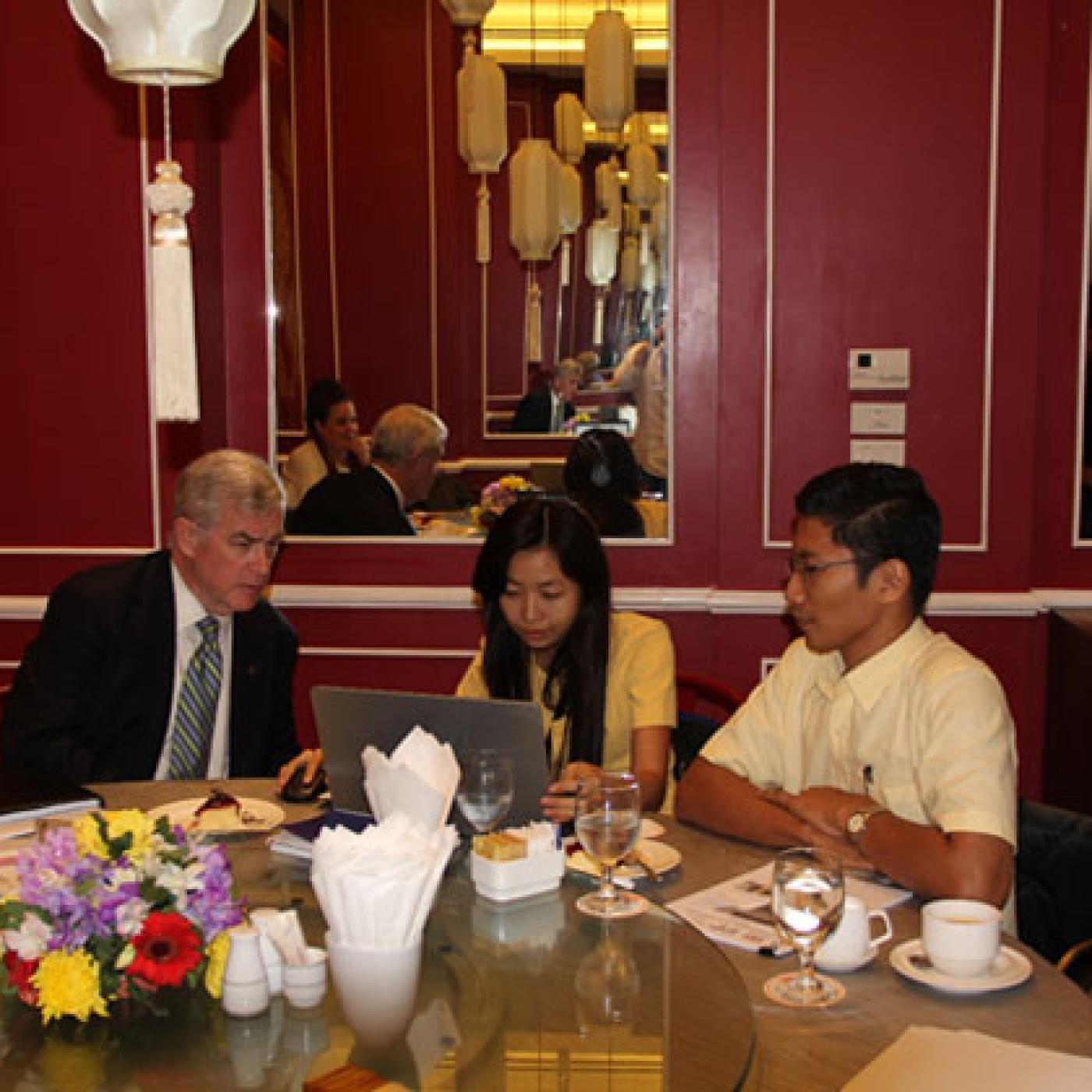 IFES President and CEO Bill Sweeney watches a voter education video, produced by the Myanmar Independent Living Initiative (MILI), with MILI Project Coordinator Theint Theint Phooe and Program Director Nay Lin Soe.