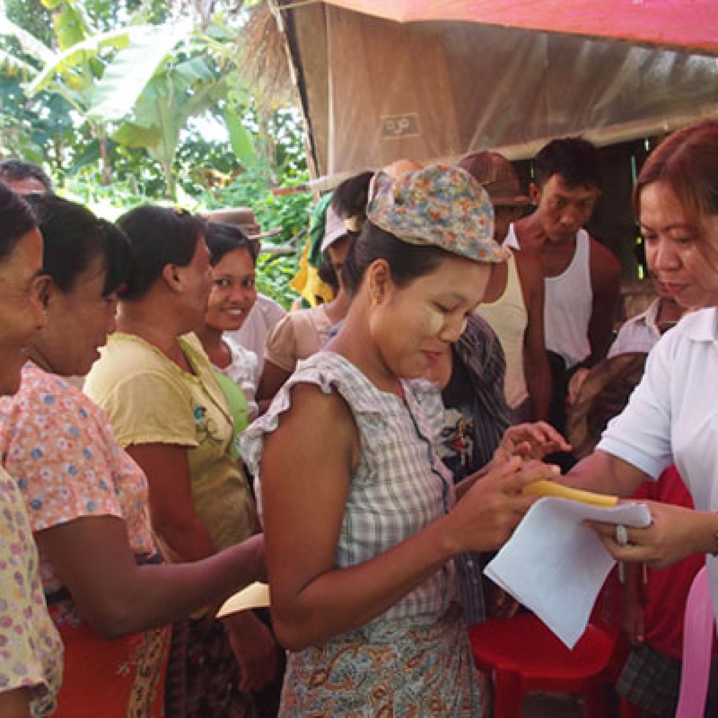 She Leads participant, Sandar Lwin explains to women in Thit Khaung Gyi how to fill in a ballot
